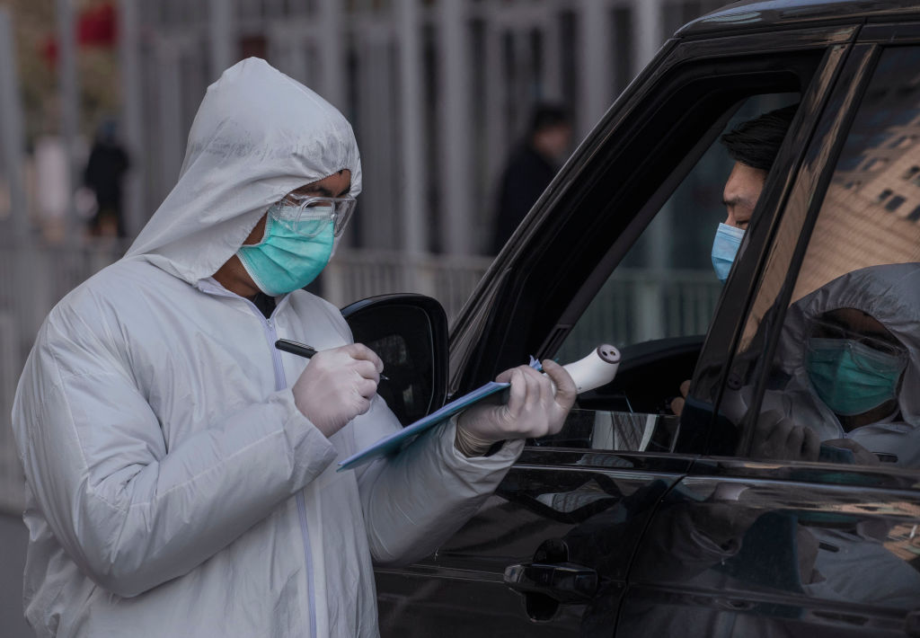 công nhân Trung Quốc mặc một bộ đồ bảo hộ khi đang kiểm tra virus corona