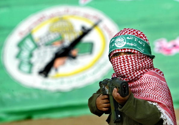 Một cậu bé người Palestine đeo mặt nạ biểu diễn các thao tác võ thuật bằng súng nhựa cho hamas